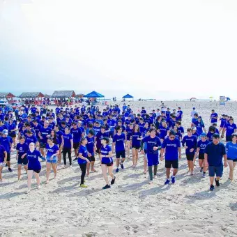 grupo grande de alumnos vestidos de azul en la playa