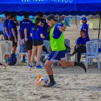 Alumnos jugando fútbol en la playa