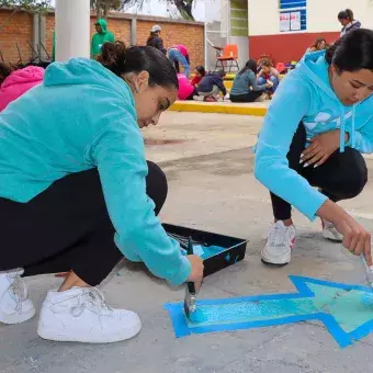 Alumnos pintando el suelo en Voluntariado Tec