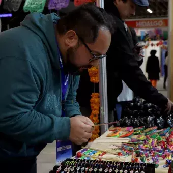 Un hombre viendo artesanías en EXPOTEC.