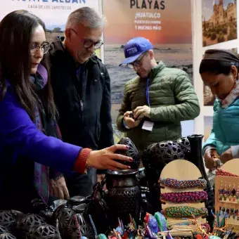 Mujer viendo artesanías en un stand de la fiesta de las culturas del Tec.