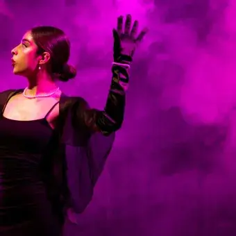 Miembro del representativo de teatro con un vestido negro en su monólogo