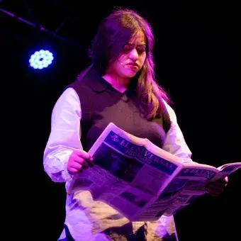 Monólogo acerca del miedo al cambio y un viaje inminente representado con una estudiante leyendo un periódico
