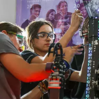 Jovenes trabajndo en su robot.