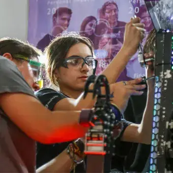 Jovenes trabajndo en su robot.