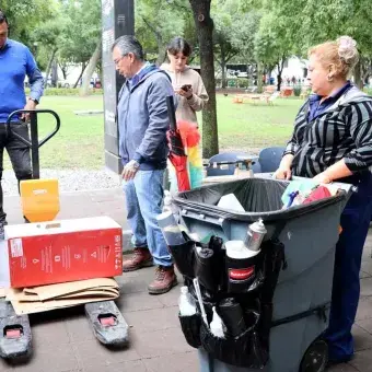 Colaboradoras llevan cartón para ser pesado.