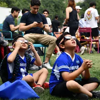 Dos niños viendo el eclipse solar desde Jardín de las Carreras.