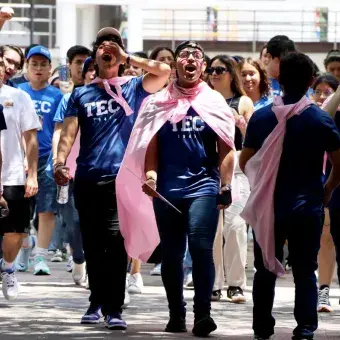 Alumnos recorren el campus mientras corean porras.