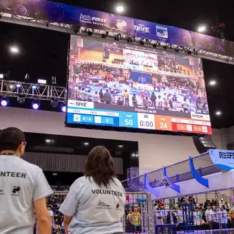 Voluntarios vigilan y apoyan a través de una pantalla lo que sucede en FIRST Regional Laguna 2025
