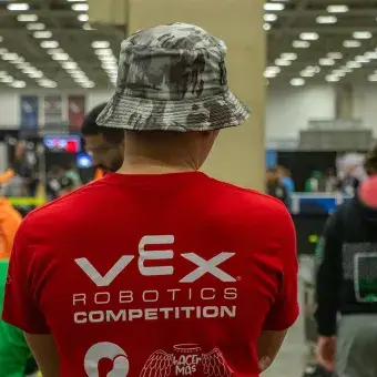 Alumno de espaldas en torneo de robótica. 