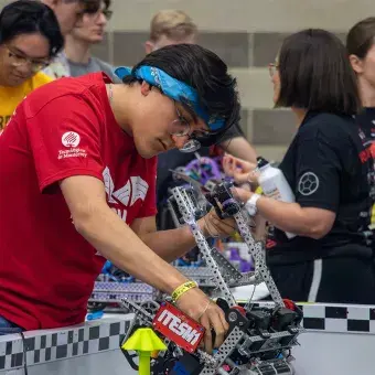 Alumno reparando un robot.