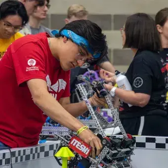 Alumno reparando un robot.