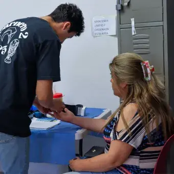 Voluntario tomando la presión arterial de una mujer. 