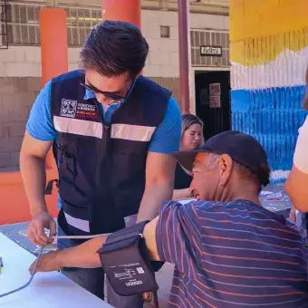 Personal de Secretaría de la Salud le toma la presión a un hombre.