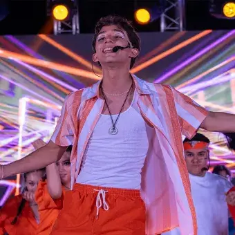 Alumno cantando y bailando en concierto. 