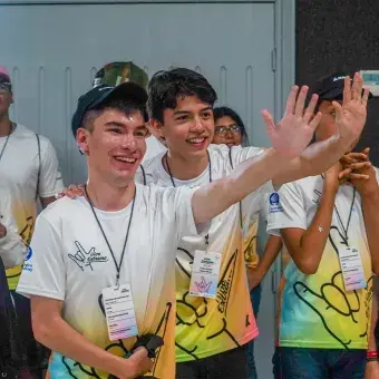 Participante y voluntario saludando en campamento Vive Extremo.