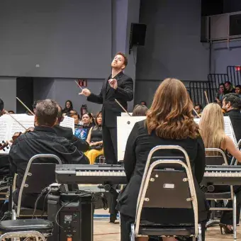 Músicos observando la dirección de Ethan Eager en concierto de la Camerta de Coahuila por el 50 aniversario del Tec de Monterrey campus Laguna