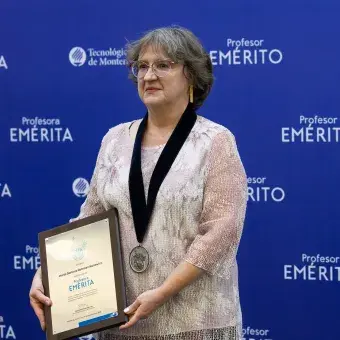 Profesora mostrando su reconocimiento en fotografía