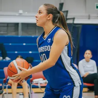 Perfil de una jugadora de básquetbol que se prepara para hacer un tiro libre. 
