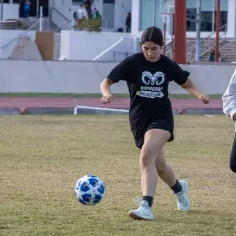 Alumnas universitarias jugando fútbol. 