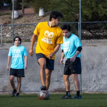 Jóvenes jugando fútbol. 