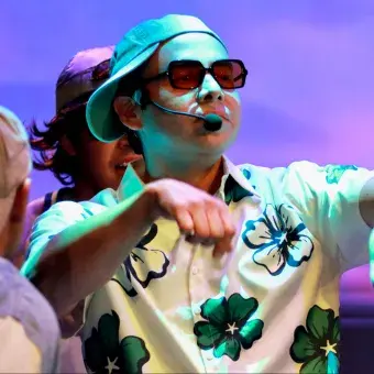 Estudiantes de la producción Legally Blonde interpretando un número musical con vestuario contemporáneo en el Teatro de la Ciudad.